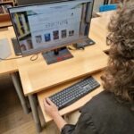 Osoba korzysta z komputera z klawiaturą w bibliotece, element wyposażenia Klubu Rozwoju Cyfrowego w Chrzanowie.