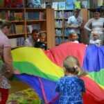 Dzieci bawią się pod chustą Klanza podczas zajęć w bibliotece.