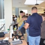 Uczniowie pod nadzorem prowadzącego obserwują pokaz dotyczący badania jakości wody.