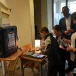 Grupa dzieci ogląda interaktywną wystawę w trakcie Małopolskiej Nocy Naukowych.