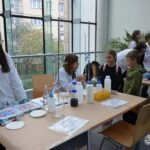 Uczniowie biorą udział w warsztatach z chemii prowadzonych przez instruktora w laboratorium szkolnym.