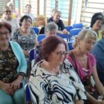 Publiczność siedzi w sali koncertowej, słuchając występu zespołu Piosenki Odkopanej.