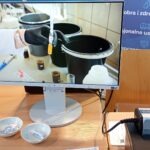 Na monitorze komputera wyświetlana jest demonstracja systemu oczyszczania wody z wykorzystaniem pojemników.