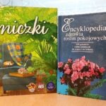 Na stole leżą dwie książki: poradnik pielęgnacji roślin doniczkowych oraz encyklopedia poświęcona zdrowiu roślin pokojowych.