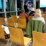 Uczestnicy siedzą w sali konferencyjnej podczas szkolenia z zakresu cyberbezpieczeństwa dla seniorów.