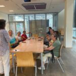 Grupa seniorów uczestniczy w warsztatach fotograficznych podczas spotkania "Pora dla Seniora".