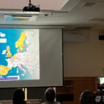 Na ekranie projekcyjnym widoczna jest mapa Europy z zaznaczonymi obszarami kolorami.