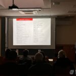 Na ekranie projekcyjnym widoczne są teksty prezentacji podczas wykładu.