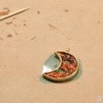 Kształt półksiężyca wypełniony jest kawałkami bursztynu osadzonymi w żywicy epoksydowej.