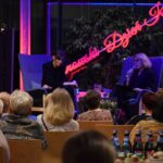 Widownia podczas wydarzenia "Kobiety Rozmową Robią" z dwiema prelegentkami siedzącymi na fotelach przed sceną.