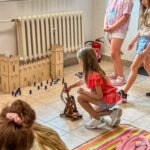 Dzieci bawią się zamkiem z klocków podczas zajęć edukacyjnych w bibliotece.