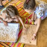 Dzieci tworzą pracę plastyczną z naturalnych materiałów podczas zajęć w bibliotece.