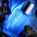 Butelka perfum Ice Touch Woman marki Mexx na tle lodowych brył.