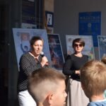 Kobiety prowadzą warsztaty edukacyjne dla dzieci przed plakatami przedstawiającymi rośliny i zwierzęta.
