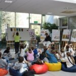 Dzieci uczestniczą w warsztatach plastycznych podczas pikniku edukacyjnego promującego ekologiczny styl życia.