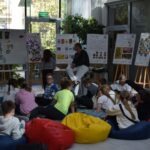 Uczniowie uczestniczą w warsztatach edukacyjnych otoczonymi plakatami informacyjnymi.