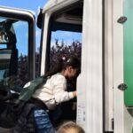Dziecko wchodzi do śmieciarki podczas warsztatów edukacyjnych dotyczących segregacji odpadów.