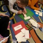 Uroczyście udekorowane domki z kolorowego papieru czekają na zmęczonego jeża w przedszkolnym ogródku.