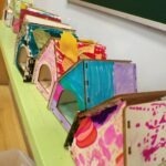 Kolorowe domki z drewna i liści zostały przygotowane jako schronienia dla jeży przez przedszkolaków.