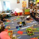 Uśmiechnięte dzieci z pasją budują kolorowe domki z klocków i liści, tworząc bezpieczne schronienia dla jeży.