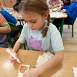 Uroczyście udekorowane domki z liści i kolorowych elementów czekają na zmęczonego jeża.