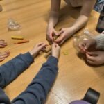 Dzieci manipulują plasteliną podczas warsztatów z zakresu nauk przyrodniczych.