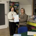 Dwie kobiety trzymają dokument podczas spotkania w bibliotece.