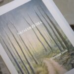 Na stronie widnieje okładka książki z tytułem "Szklarz Świata" oraz nazwiskiem Mirosława Janika.