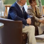 Dwóch mężczyzn siedzi obok siebie na krzesłach w pomieszczeniu, prawdopodobnie podczas spotkania Akademii Słowa.