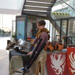 Mężczyzna przebrany za rycerza siedzi na stołku przed stoiskiem z rekwizytami w trakcie ChrzanConu.