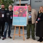 Pięciu osób stoi obok plakatu promującego wydarzenie ChrzanCon poświęcone fantastyce i popkulturowym inspiracjom.