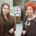 Dwie kobiety pozują do zdjęcia w bibliotece podczas wydarzenia ChrzanCon.