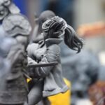 Model miniature przedstawia postać kobiety w zbroi trzymającą dziecko.