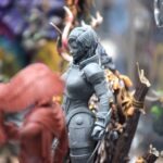 Model figurek przedstawia wojownika w zbroi stojącego obok postaci przypominającej gnoma z brodą.