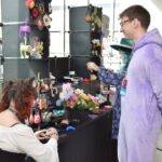 Mężczyzna rozmawia z pracownikiem stoiska podczas wydarzenia poświęconego popkulturowym inspiracjom.