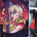 Na planszy widnieje postać w stylu komiksowym z krwawymi ranami trzymającą narzędzia.