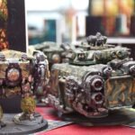 Na stole znajdują się pomalowane modele bitewne w stylu science fiction.