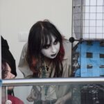 Uczestniczka konkursu cosplay prezentuje postać z makijażem w stylu zombie.