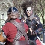 Dwóch rekonstruktorów rycerskich prezentuje swoje stroje podczas pokazu walki na ChrzanConie.