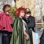 Uczestnicy ChrzanConu przebrani w kostiumy elfów, rycerza oraz postaci z gier RPG pozują do zdjęcia na tle budynków.