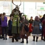 Uczestnicy konwentu ChrzanCon pozują do zdjęcia z postacią w przebraniu leśnego boga, ozdobionego porożem.