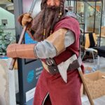 Uczestnik konkursu cosplay wciela się w postać krasnoluda z mieczem w ręku.