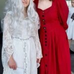 Dwie osoby przebrane za postaci z literatury fantasy pozują w strojach białej i czerwonej sukni.