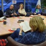 Uczestnicy Dyskusyjnego Klubu Książki siedzą przy stole podczas spotkania poświęconego powieści "Nieczułość".