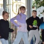 Dzieci w kolorowych skarpetkach bawią się podczas wydarzenia promującego akceptację i empatię.