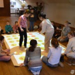 Dzieci uczestniczą w zajęciach na interaktywnej podłodze FunFloor w bibliotece.