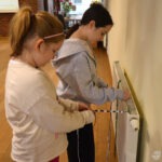 Dwie dziewczynki bawią się interaktywną podłogą FunFloor w bibliotece.