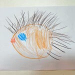 Narys przedstawia jeża z pomarańczowym tułowiem i niebieskim okiem, wykonany kredkami na białym papierze.