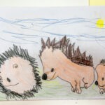 Na rysunku przedstawiono trzy jeże z charakterystycznymi kolcami, wykonane kredkami na papierze w pastelowych barwach.