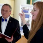 Dwóch ludzi przemawia podczas wystąpienia publicznego w sali konferencyjnej.